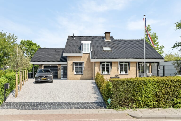 Huis met oprit en groene heg
