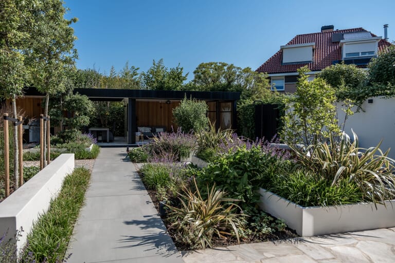 Zonnige tuin met veel groen en veranda