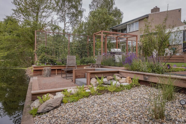 Groene tuin met terrasje aan het water