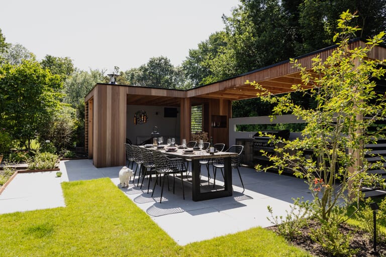 Zonnige tuin met veranda en buitenkeuken