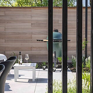 Tuin met mediterrane bomen, aluminium pergola en overkapping