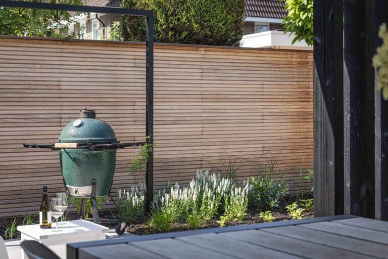 Tuin met mediterrane bomen, aluminium pergola en overkapping