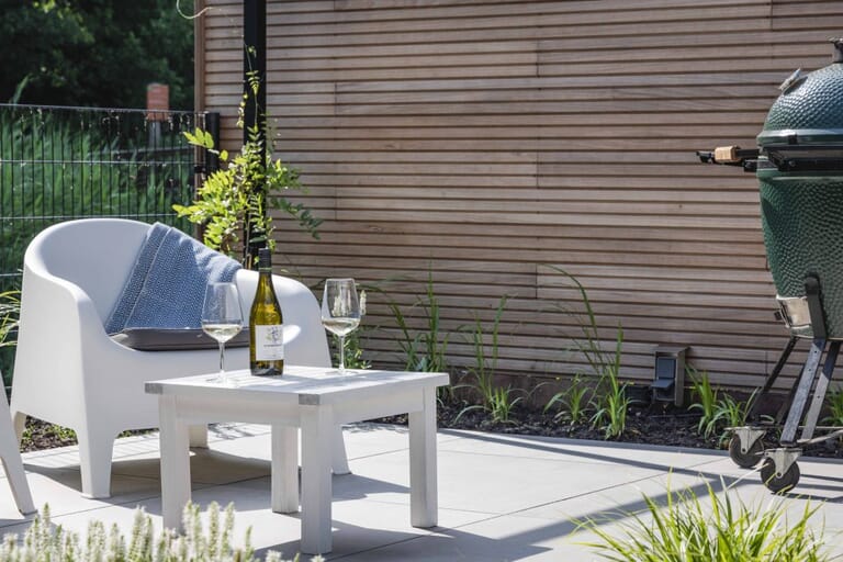 Tuin met mediterrane bomen, aluminium pergola en overkapping