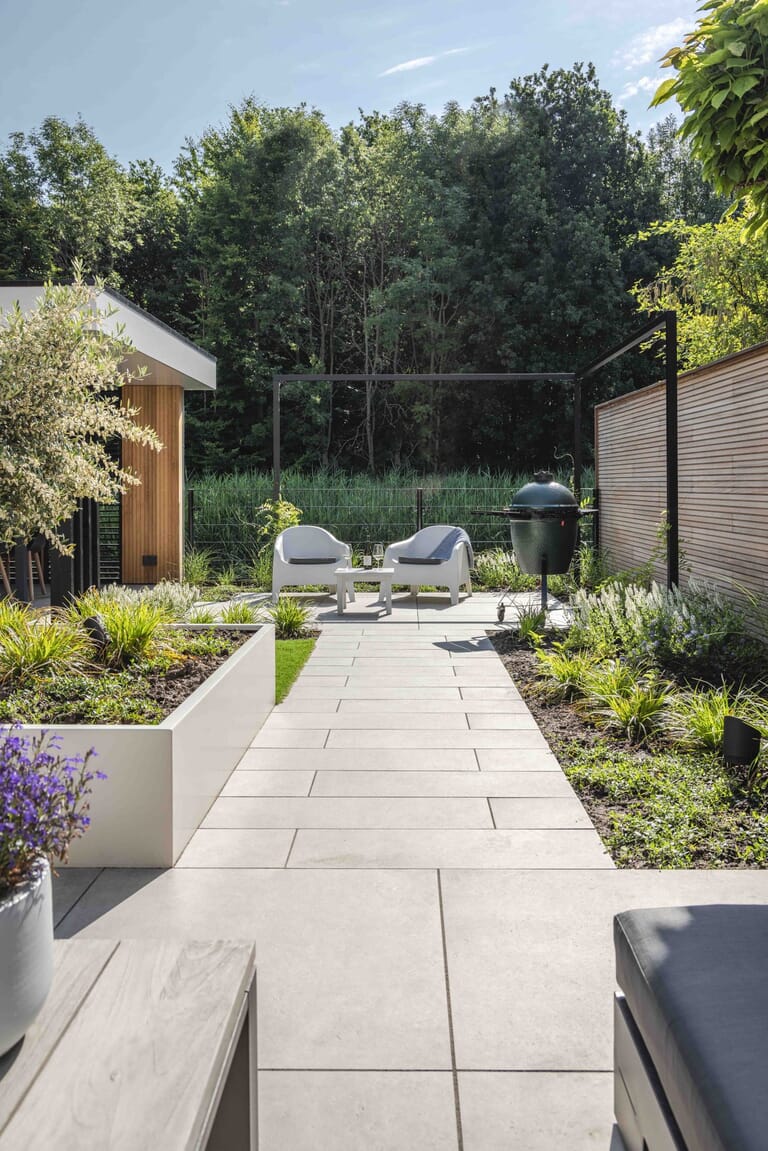 Tuin met mediterrane bomen, aluminium pergola en overkapping