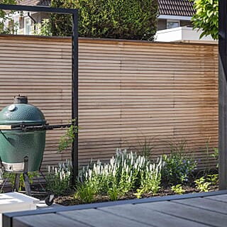 Tuin met mediterrane bomen, aluminium pergola en overkapping