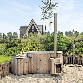 Ruimtelijke wellness tuin met hottub en buitendouche