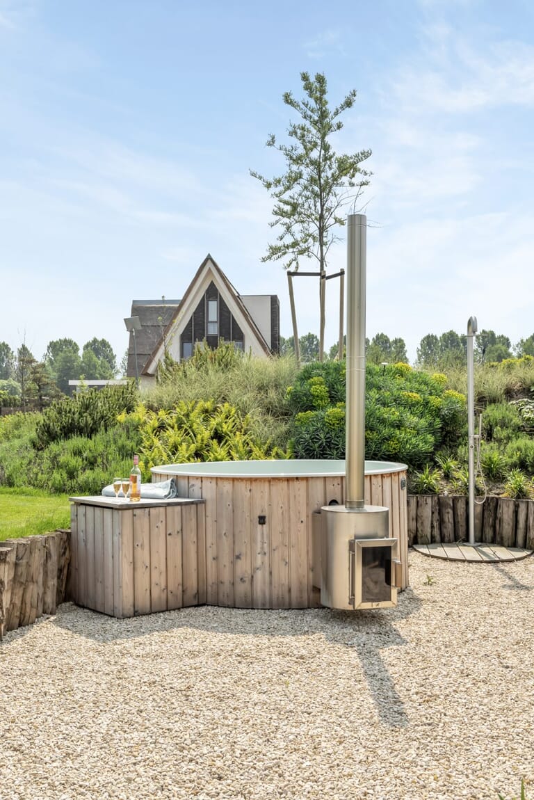 Ruimtelijke wellness tuin met hottub en buitendouche