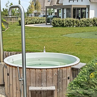 Ruimtelijke wellness tuin met hottub en buitendouche