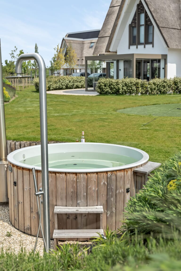 Ruimtelijke wellness tuin met hottub en buitendouche