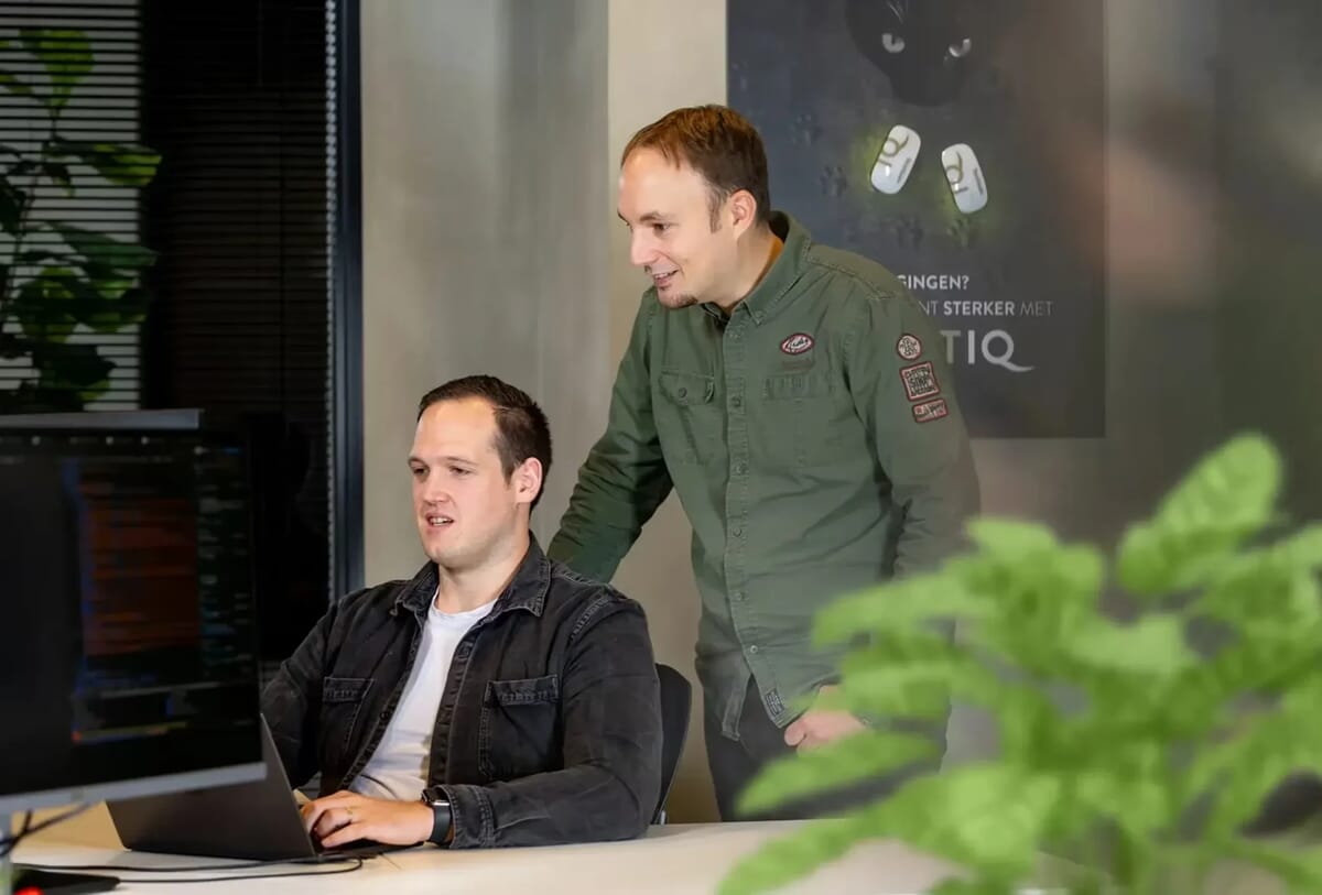 Twee mannen kijken op een scherm voorzich