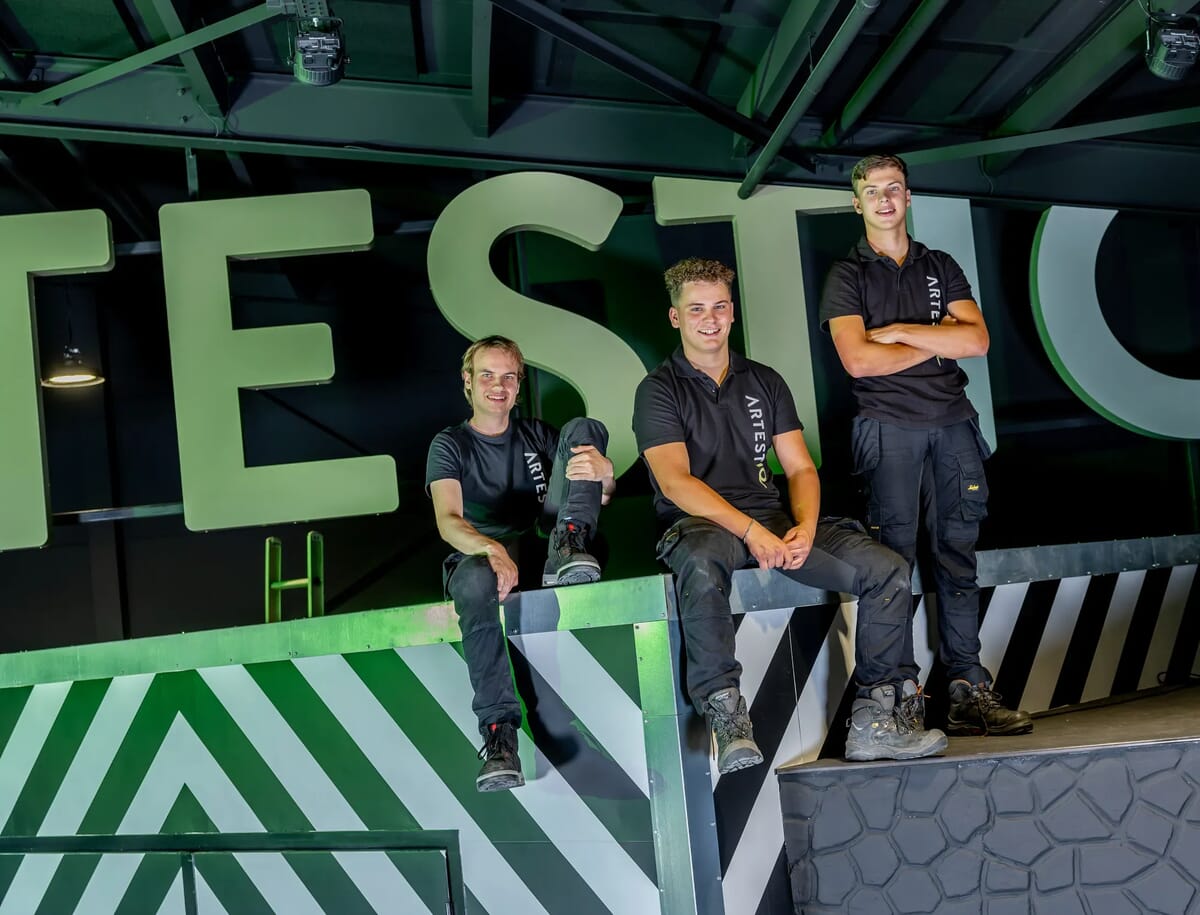 3 mensen op een muur