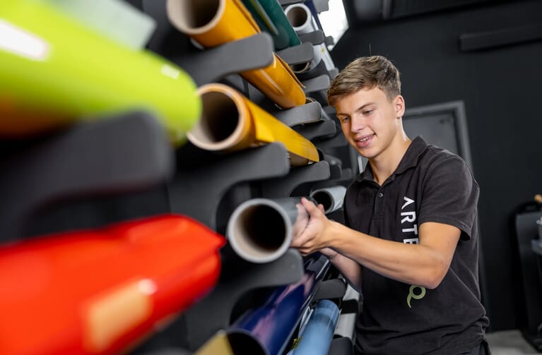 Man staat naast een wand vol folies