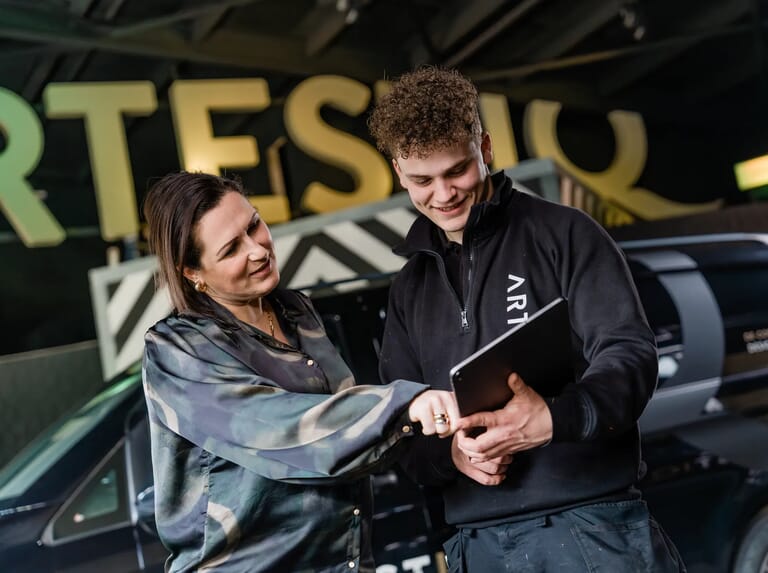 Een vrouw naast een jongen en kijken naar tablet