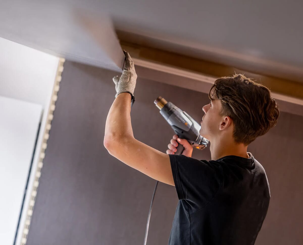 Iemand trekt iets glad met een föhn