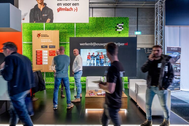 Foto van een beurs waar mensen voorbij lopen