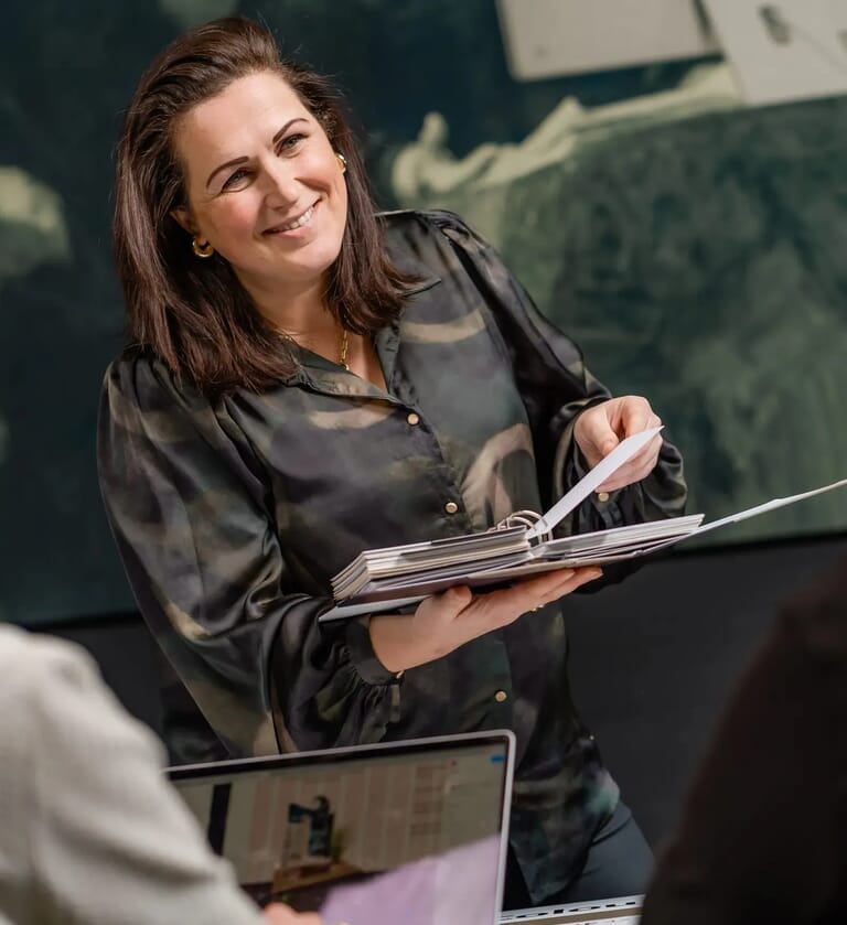 Vrouw staat met een map inhaar handen