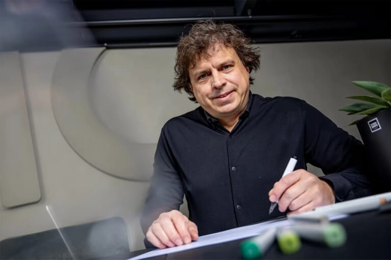 Een man aan tafel die tekent