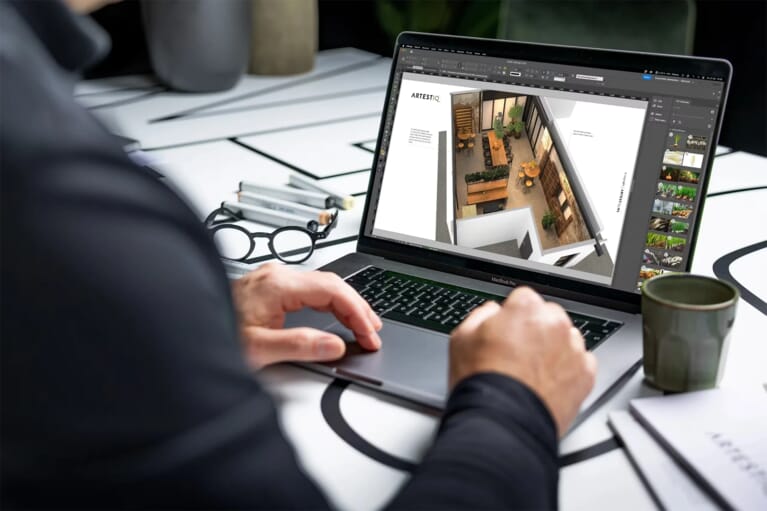 Iemand achter een laptop met een visualisatie voorzich van een winkel