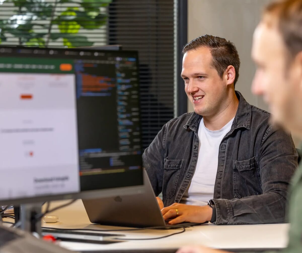 Twee mannen die achter een beelscherm zitten
