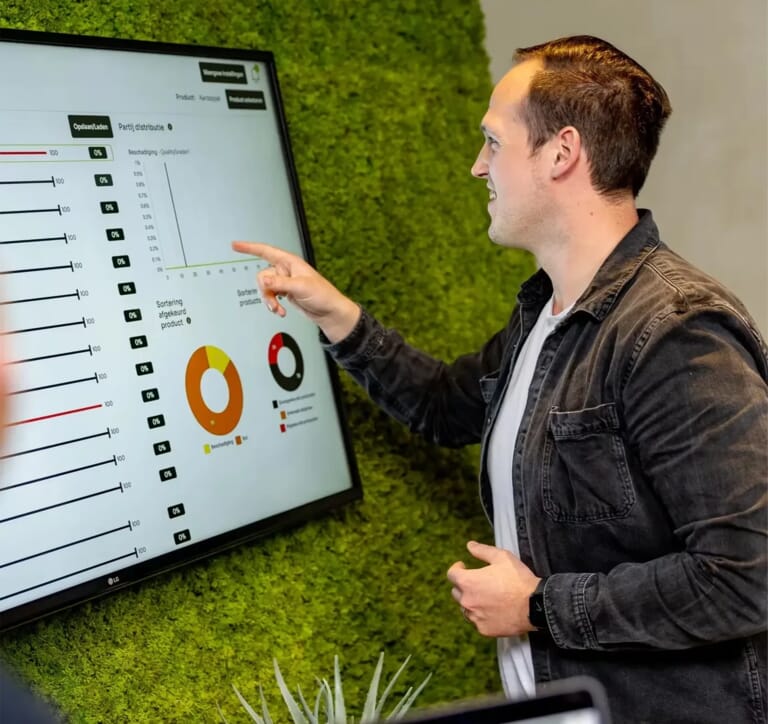 Een man wijst naar een tv scherm