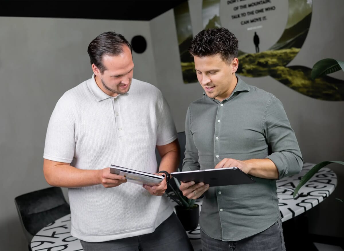 Twee mensen naast elkaar kijken naar een tablet