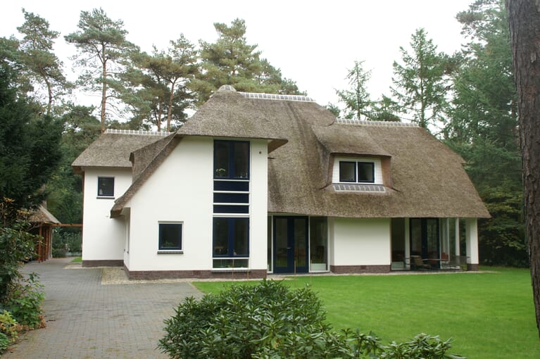 Wit gestucte woning met rieten kap