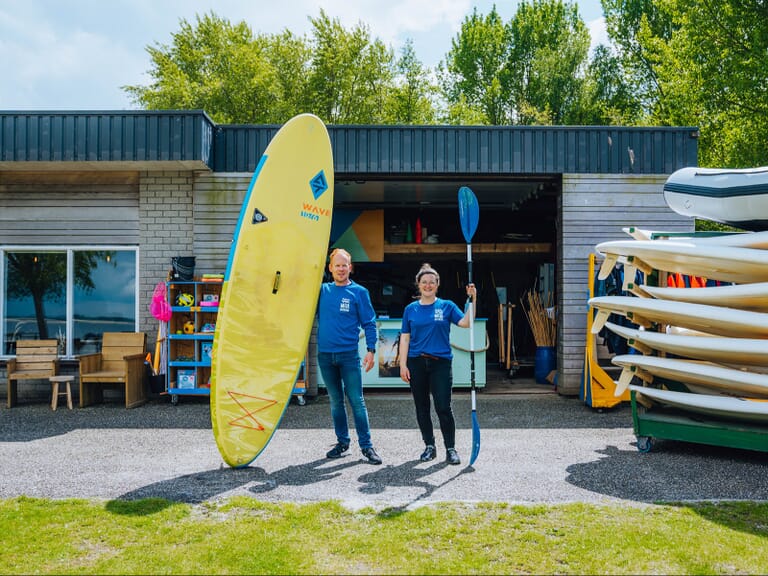 Twee mensen voor een schuur met waterartikelen