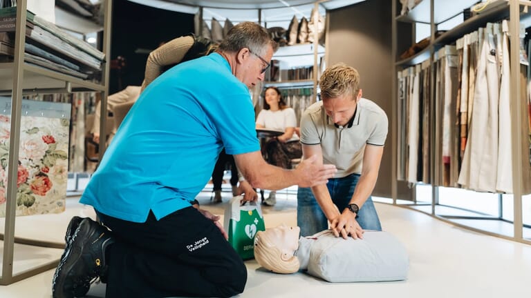 Twee mannen die bezig zijn met reanimatie op oefenpop
