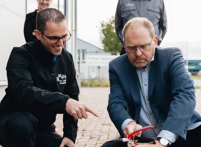 Twee mannen de ene wijst naar een brandblusser
