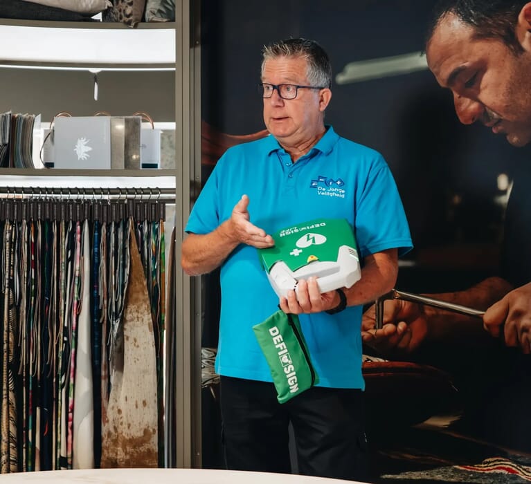 Een man met een AED in zijn handen