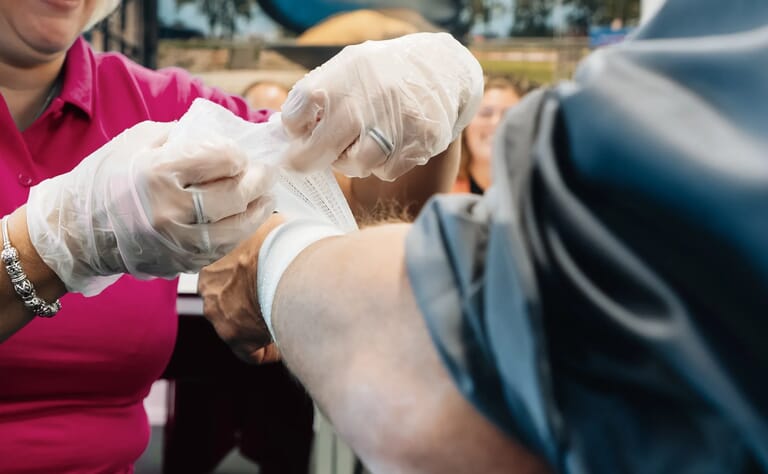 Iemand doet verband rond een arm