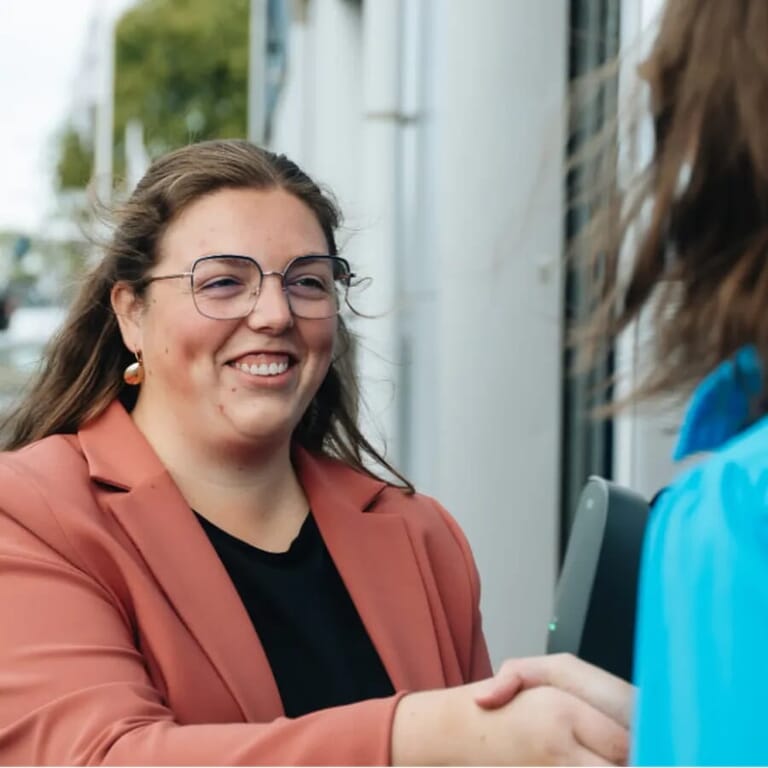 Een vrouw schut de hand van iemand