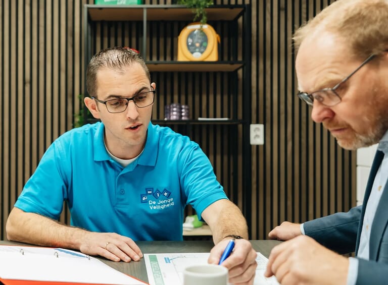 Een man wijst en legt iets uit aan een andere man