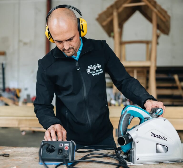 Man keurt een boormachine