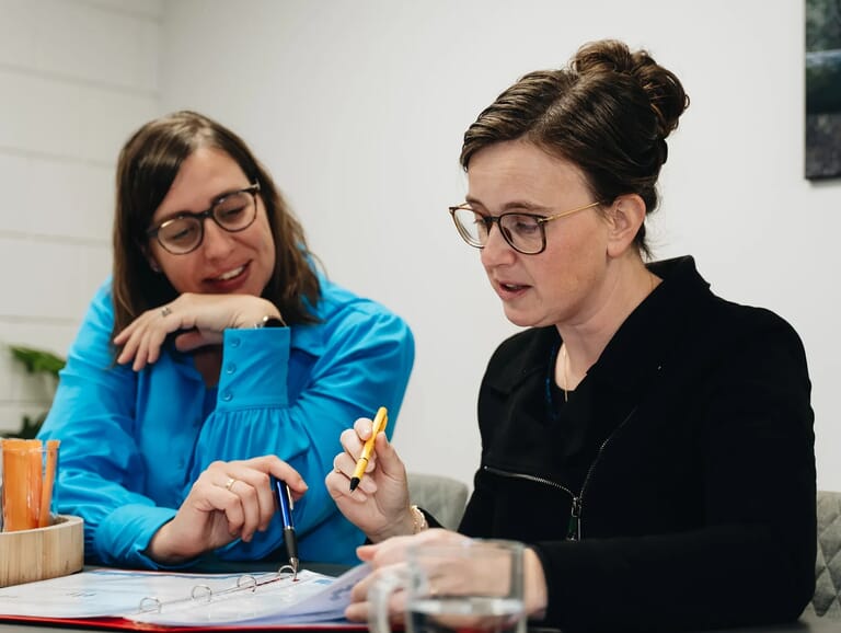 Twee vrouwen die beide in een boek kijken