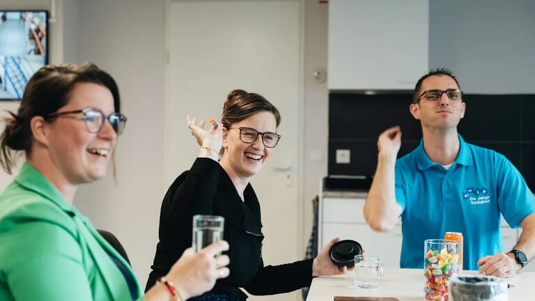 Mensen aan een tafel die lachen