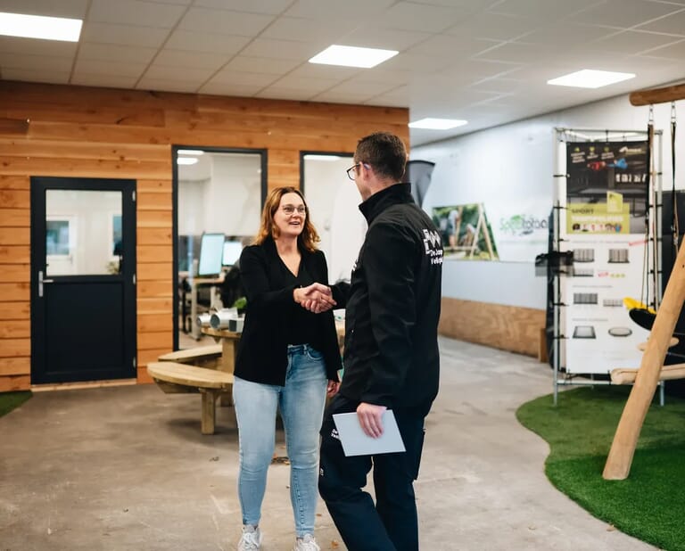 Een man en vrouw schudden elkaar de hand