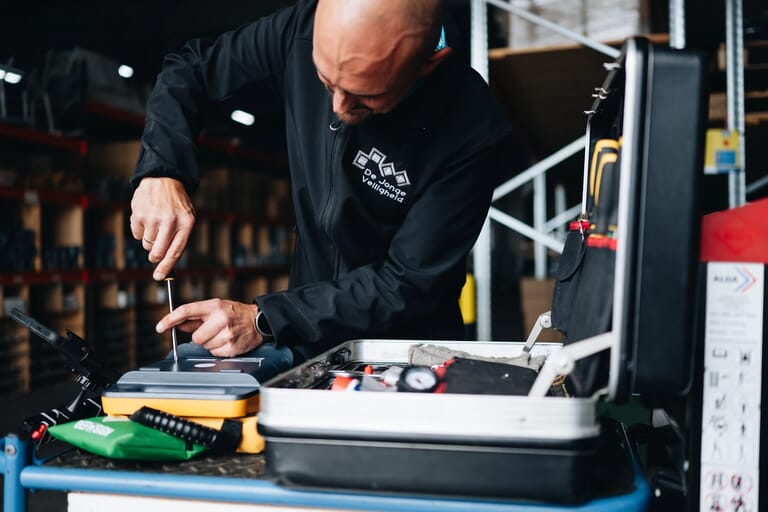 Een man sleutelt aan iets met een schroeverdraaier