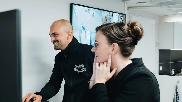 Twee mensen kijken naar beveiligingscamera