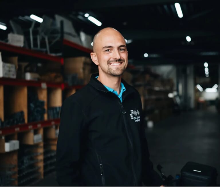 Een man lacht naar de camera