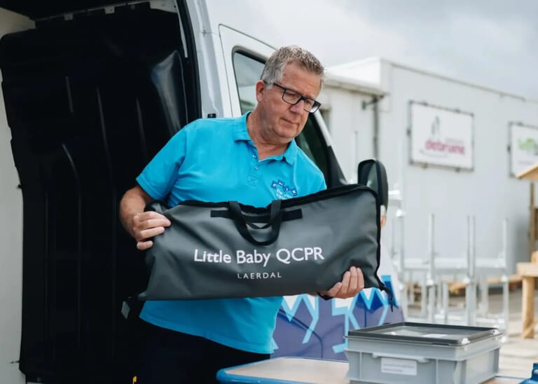 Een man tilt een zak uit zijn bus