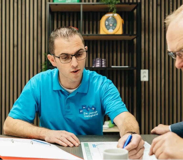 Een man wijst en legt iets uit aan een andere man