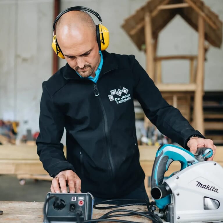 Man keurt een boormachine