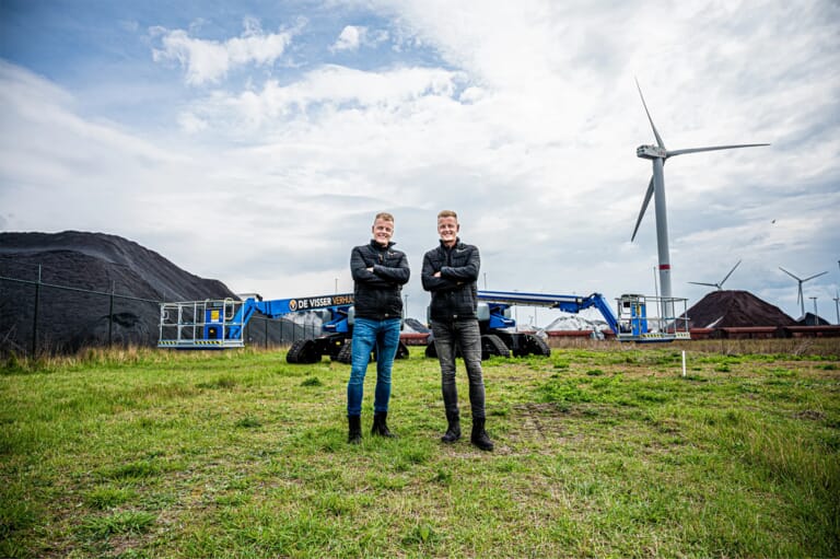 Twee mannen met de armen over elkaar op een industrie terrein