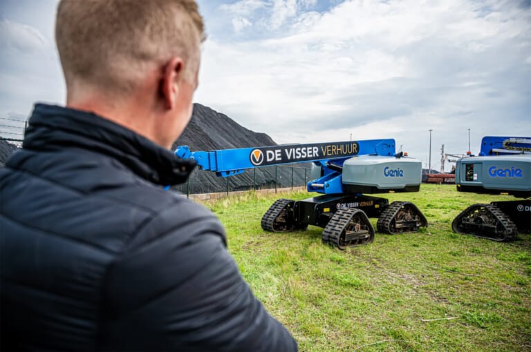 Man met daarachter een hoogwerker