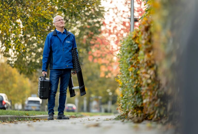 Een man kijkt omhoog op straat