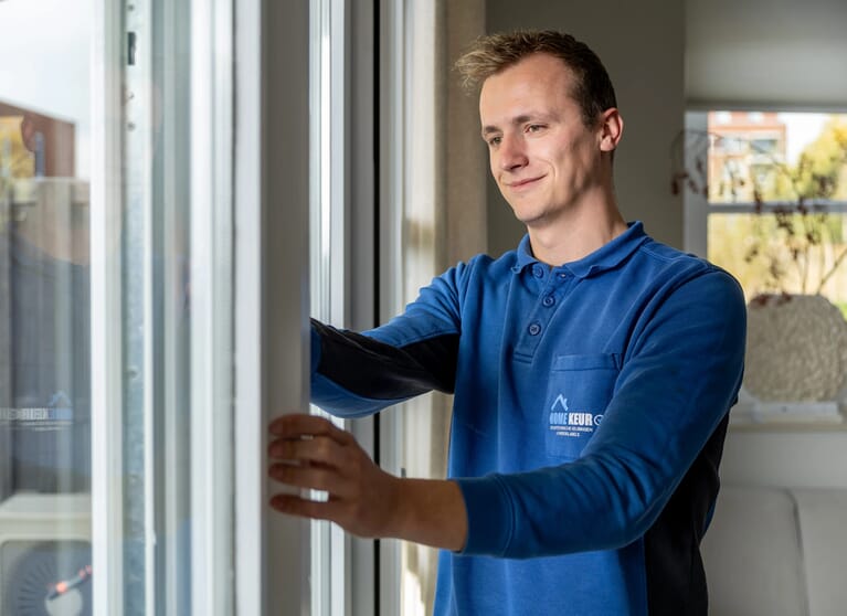 Een man controleert een kozijn