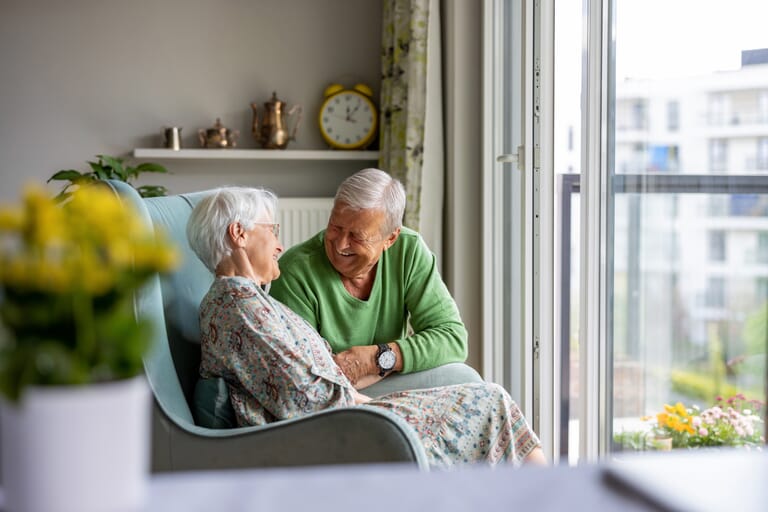 Ouder-stel-zit-en-lacht-in-zorgkamer