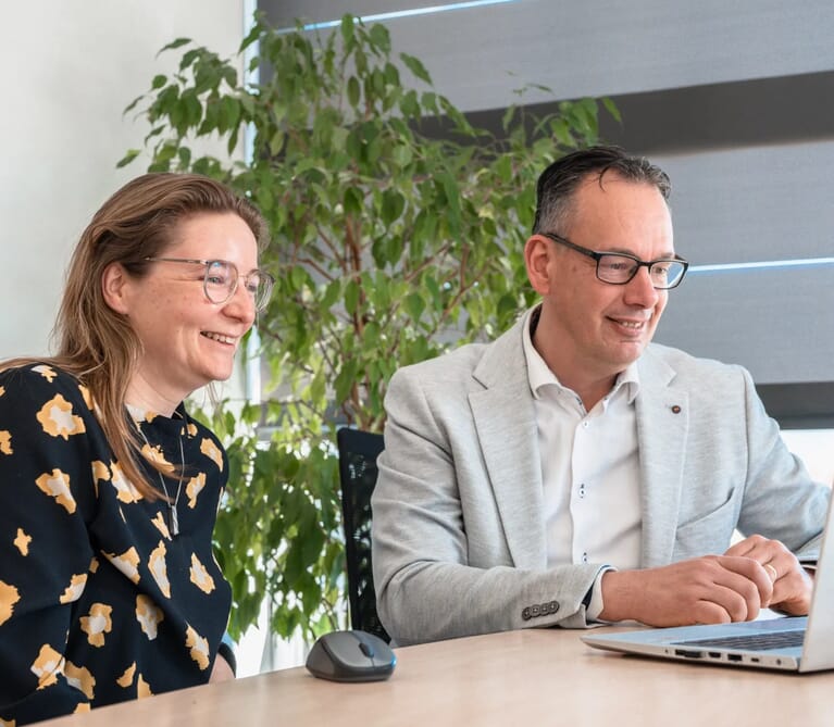 Twee mensen kijken naar ene laptop