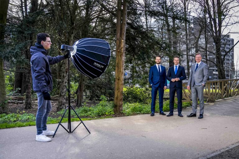 Drie mannen in bak en daarvoor staat een licht die een camerman afstelt